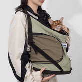 Front-facing cuddle pet carrier backpack with cat inside, featuring wide shoulder straps, breathable mesh
