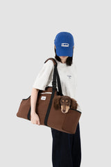 Brown Baguette dog carrier worn over the shoulder with a dachshund inside.