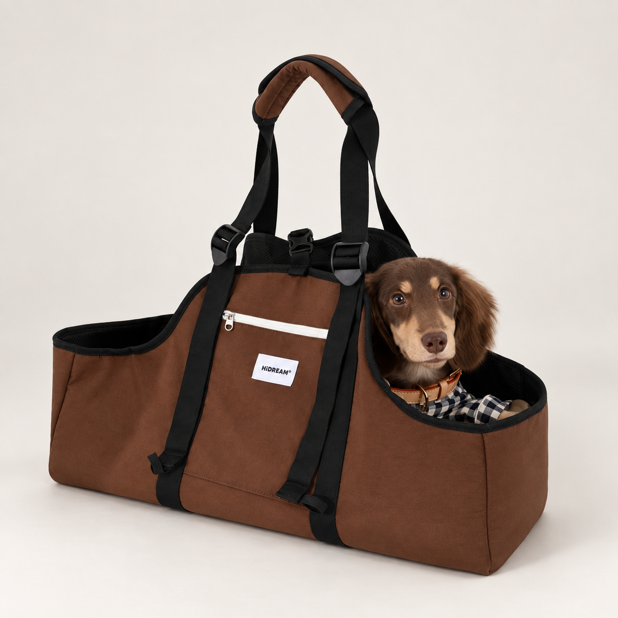 Brown Baguette shoulder carrier with a dachshund against a warm neutral studio background.