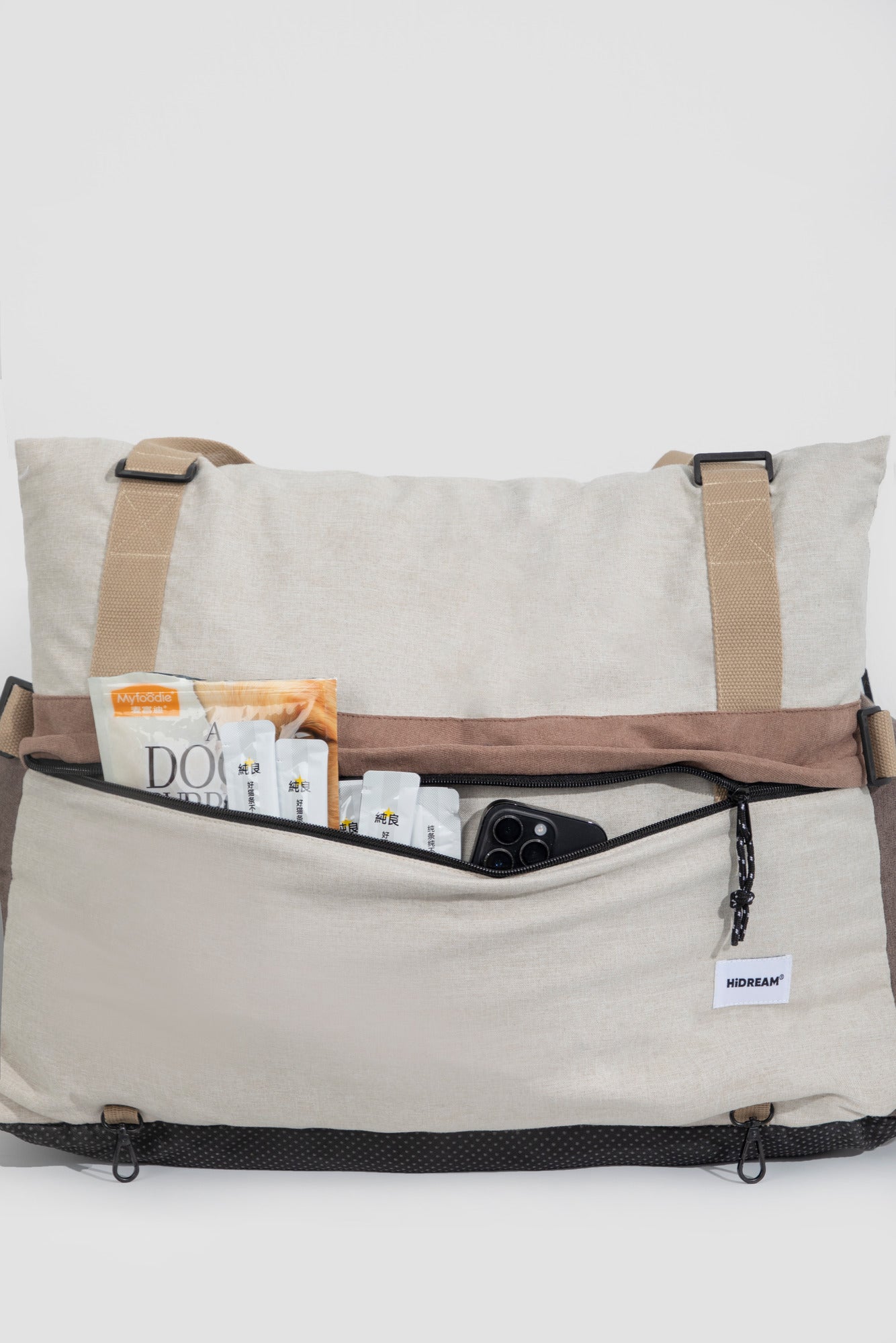 Zipped outer storage pocket on the pet bed holding a phone and small travel items.