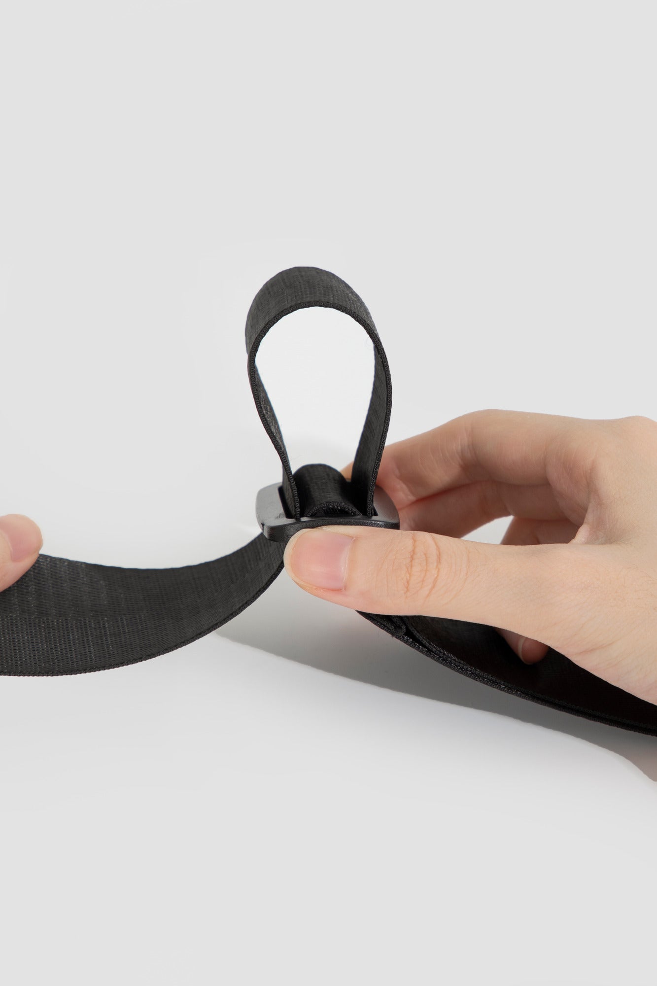 Close-up of the black webbing strap and sliding length adjuster.