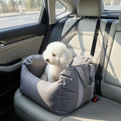 Dog in a gray pet seat in a car
