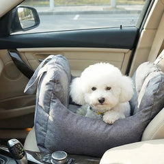 White dog in a gray car seat inside a vehicle